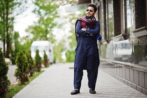 élégant homme arabe musulman indien pakistanais en costume kurta dhoti et lunettes de soleil. photo