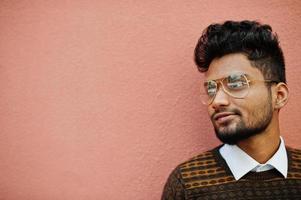 portrait de jeune homme indien élégant modèle à lunettes isolé sur fond de mur rose. photo