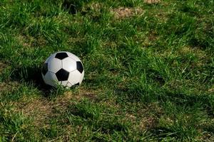 ballon de football ou de football noir et blanc sur l'herbe verte. photo