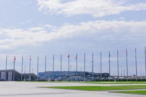 sotchi, russie, 2019 - parc olympique de sotchi en été. vue sur l'iceberg du palais de glace et les drapeaux des pays participants aux jeux olympiques photo