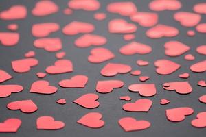 fond sombre avec des confettis coeurs rouges pour la saint valentin. mise au point sélective. concept festif et de vacances. photo