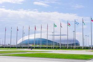 sotchi, russie, 2019 - parc olympique de sotchi en été. vue sur le stade de football fisht et vawing les drapeaux des pays participants aux jeux olympiques photo