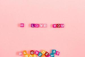 je t'aime inscription faite de perles de cube colorées avec des lettres. concept de fond rose festif avec espace de copie photo