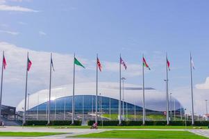 sotchi, russie, 2019 - parc olympique de sotchi en été. vue sur le stade de football fisht et vawing les drapeaux des pays participants aux jeux olympiques photo