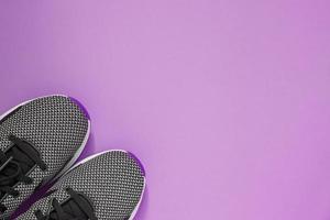 chaussure de sport sur fond violet. baskets féminines noires et blanches pour l'entraînement. concept de style de vie avec espace de copie. vue de dessus photo