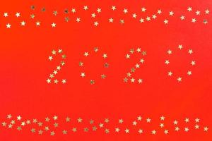 bonne année 2020 modèle de conception de carte de voeux de vacances d'hiver. affiche de fête, bannière ou invitation étoiles scintillantes argentées décoration de paillettes de confettis sur fond rouge photo