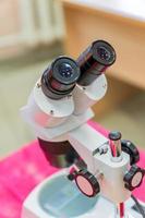 équipement de laboratoire, microscope optique pour les cours scolaires sur tableau rouge photo