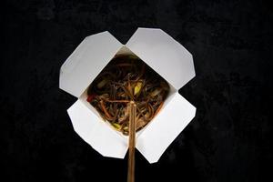 restauration rapide asiatique dans une boîte. udon aux légumes et boeuf photo