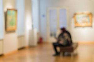 image défocalisée des personnes visitant le musée d'art. les gens regardent des peintures sur le mur photo