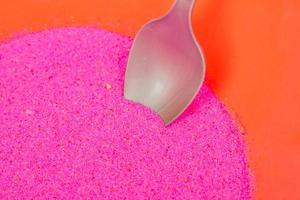 sable rose coloré dans un bol en plastique. atelier de création d'images de sable pour les enfants photo