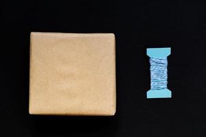 coffret cadeau artisanal enveloppé dans du papier kraft avec ruban bleu et arc photo