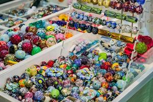 mélange coloré de perles de verre au chalumeau. variété de formes et de couleurs pour faire des colliers ou des bracelets. matériaux de bricolage photo