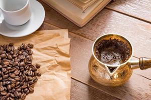 grains de café torréfiés frais dans une cafetière turque traditionnelle cezve livre ouvert et tasse sur une table en bois. photo