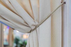 élément de design d'intérieur - rideaux beiges attachés avec un cordon, style italien photo