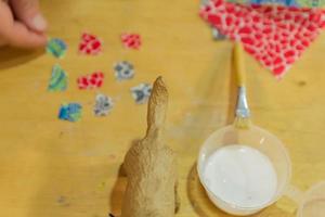 atelier décopach. vue de dessus de la table avec figurine de chien, papier et colle photo