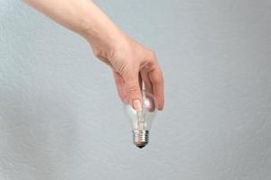 main de femme tenant l'ampoule. idée et concept d'entreprise. photo