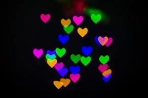 fond de coeur bokeh, concept d'amour et de saint valentin. lumière de coeurs brillants multicolores photo