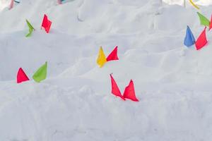 drapeaux multicolores dans une neige. poste de contrôle des compétitions de sports d'hiver. photo