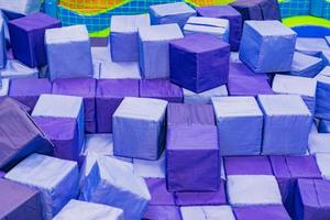 beaucoup de blocs bleus doux dans une piscine sèche pour enfants à l'aire de jeux. jouets géométriques. photo