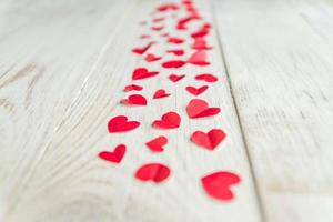 beaucoup de coeurs rouges en papier découpé sur fond de bois, perspective, mise au point sélective photo