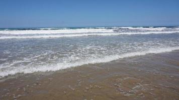 vague douce d'océan bleu sur la plage de sable. photo