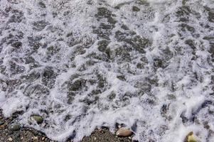 vague de mer sur la côte de galets. fond naturel. éclaboussures d'eau photo