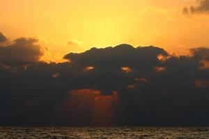le soleil se couche sous l'horizon sur la mer méditerranée dans le nord d'israël. photo