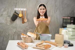 belle jeune femme cuisine dans sa cuisine, sa boulangerie et son café photo