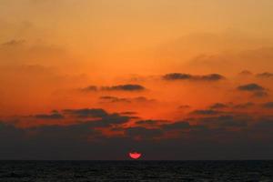 le soleil se couche sous l'horizon sur la mer méditerranée dans le nord d'israël. photo