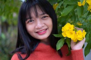 portrait jeune fille aux fleurs jaunes, fille asiatique. photo