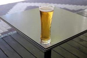 sur la table du restaurant un verre de bière fraîche et froide. photo