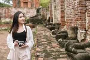 belle jeune femme voyageant et prenant des photos au parc historique thaïlandais, vacances et concept de tourisme culturel.