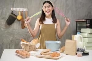 belle jeune femme cuisine dans sa cuisine, sa boulangerie et son café photo