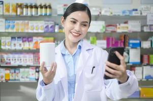 une pharmacienne conseillant une cliente par appel vidéo dans une pharmacie de pharmacie moderne. photo