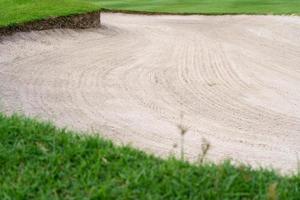 Le fond de beauté du bunker de bac à sable est utilisé comme obstacle pour les tournois de golf pour la difficulté. et décorer le terrain pour l'herbe beauty.green avec une texture de sable. photo