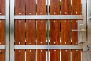 porte en bois à angle étroit devant la maison, le système automatique peut être déplacé avec des roues sur le côté, la télécommande, la porte est en bois mélangé avec de l'acier inoxydable, la sécurité et la décoration de la maison pour la beauté photo