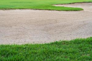 Le fond de beauté du bunker de bac à sable est utilisé comme obstacle pour les tournois de golf pour la difficulté. et décorer le terrain pour l'herbe beauty.green avec une texture de sable. photo