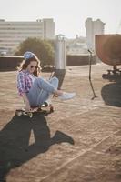 femme de mode posant sur une planche à roulettes photo