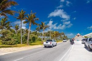 suv roulant sur la route avec des palmiers par une journée ensoleillée près de cancun, mexique photo