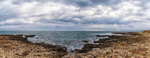 superbe paysage marin panoramique avec des nuages pittoresques sur la mer avec un rivage rocheux photo
