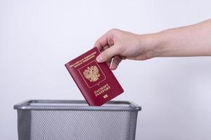 passeport de la fédération de russie dans une poubelle. l'homme jette le passeport à la poubelle. photo