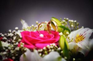 bague de mariage en or avec des roses roses et des lys blancs en gros plan photo