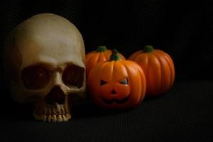 le cric de citrouille d'halloween et le crâne en image de fond de vacances noir. photo