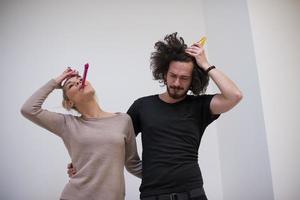 couple en chapeaux de fête soufflant dans un sifflet photo