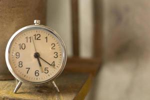 alarme d'horloge vintage blanche près de la lumière de la fenêtre. photo