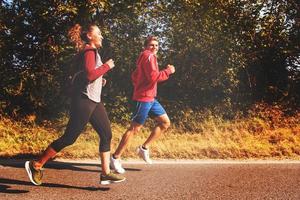 jeune couple faisant du jogging le long d'une route de campagne photo