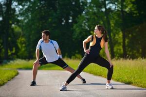 couple faisant des exercices d'étirement après le jogging photo