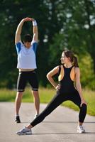 couple faisant des exercices d'étirement après le jogging photo