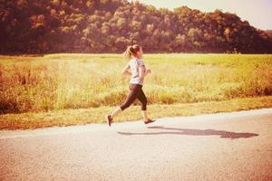 femme faisant du jogging le long d'une route de campagne photo