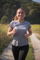 femme faisant du jogging le long d'une route de campagne photo